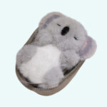 Grey koala cuddly plush lying in a cute little cradle sleeping on a plain background