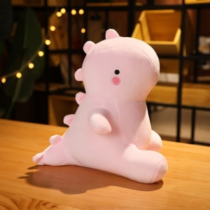 Cute pink dinosaur plush sitting on a table