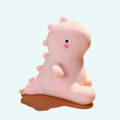 Cute pink dinosaur plush sitting on a table