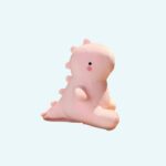 Cute pink dinosaur plush sitting on a table