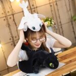 Black Toothless dragon plush. Toothless has yellow eyes and scales on his back. His wings are spread.