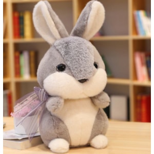 Grey rabbit plush on a table in front of a piece of furniture