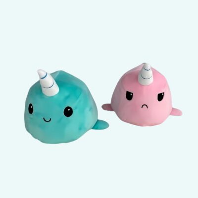 Green unicorn whale plush on a light blue background.