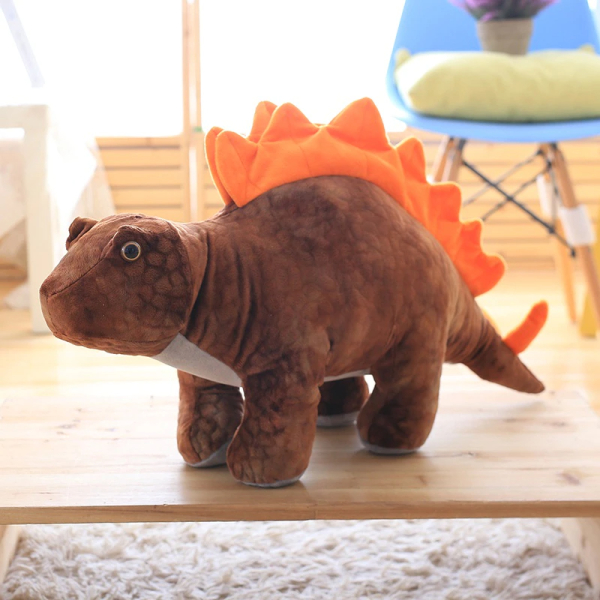 Brown and orange stegosaurus plush, in a room in front of a blue chair