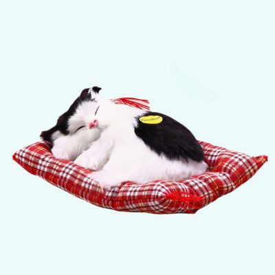 Cuddly plush black and white sleeping cat on a light blue background.