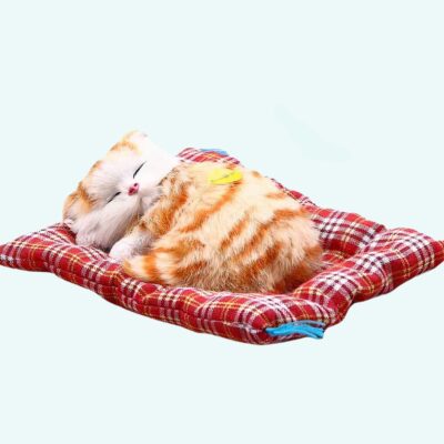 Cuddly plush sleeping cat with red tabby on a light blue background.