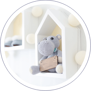 Hipopotamus plush in a small white wooden house