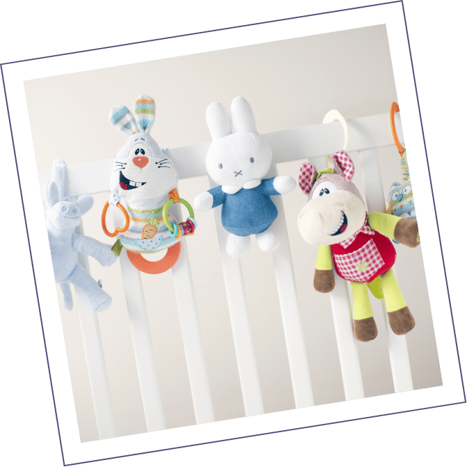 Several stuffed animals hanging from a railing
