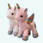 Rainbow coloured unicorn plush toy, one pink and one white, on a light blue background.