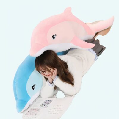Dolphin plush for girl on a bed with girl in tow