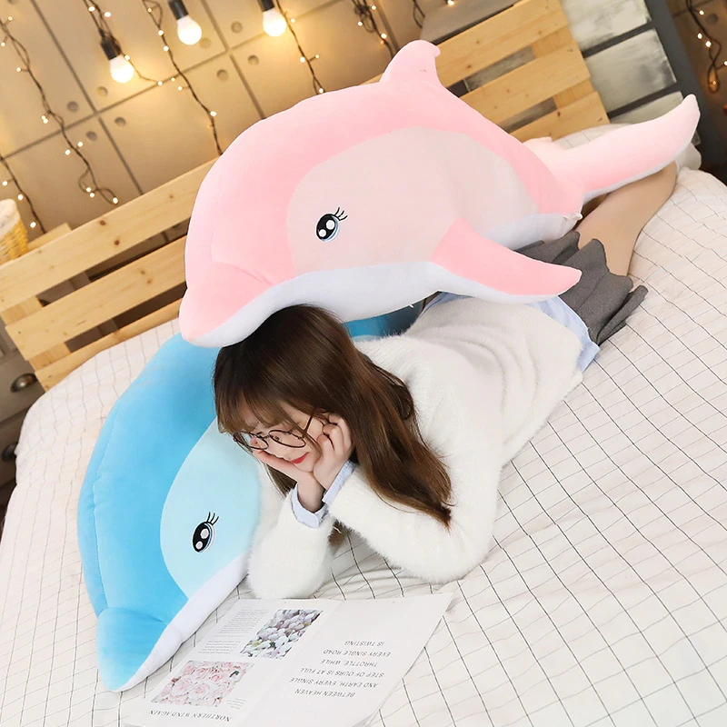 Dolphin plush for girl on a bed with girl in tow