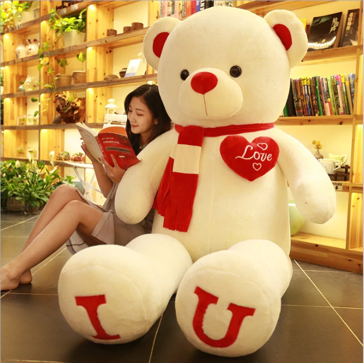 Teddy bear with red scarf with a woman reading a book
