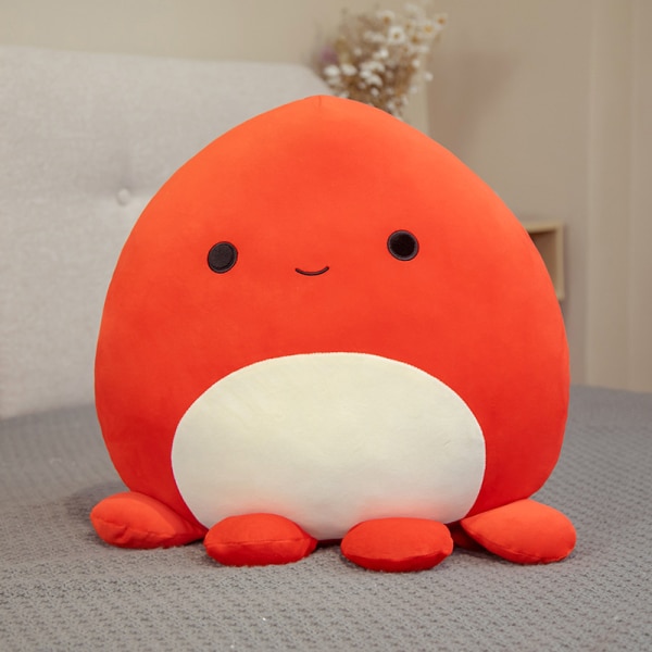 Soft octopus pillow orange on a bed