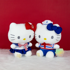 Hello Kitty sailor style plush sitting in front of a red wall