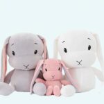 Cute pink, grey and white plush bunny for children on a white background