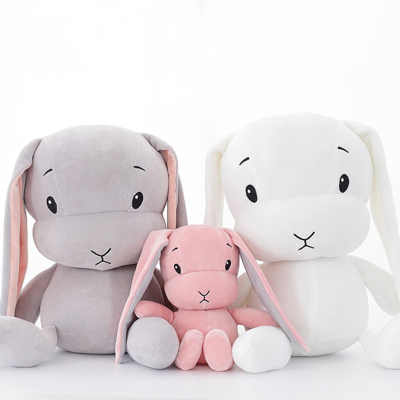 Cute pink, grey and white plush bunny for children on a white background