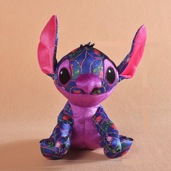 Stitch the disney cartoon hero plush who is coloured in dark purple with red rose patterns, and pink ears and belly, he is sitting with his ears in the air