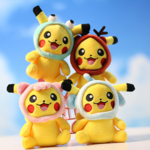 Four plush pikachu keychains wearing a small coloured bonnet, one blue, the second brown, the third pink and the last white, and two of them are on top of the other two, on a blue sky background with clouds