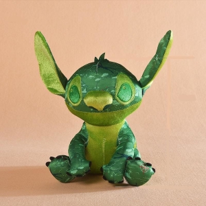 Stitch, the disney cartoon hero, is a dark green plush, with light green ears and belly, sitting with his ears up