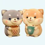 Grey and beige Bubble Tea cuddly toys in the shape of a dog standing on its hind legs with a small pocket between its front legs on a beige bed sheet