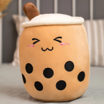 Bubble tea cushion plush, round and brown, laughing. She has black spots on her belly