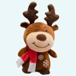Brown deer plush with red scarf on a grey and white sofa