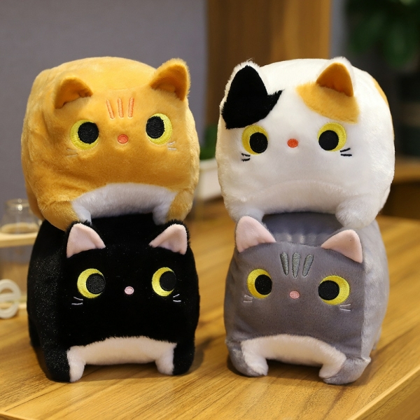 Four square cat plush toys on a wooden table. A yellow cat on a black cat and a white cat on a grey cat.