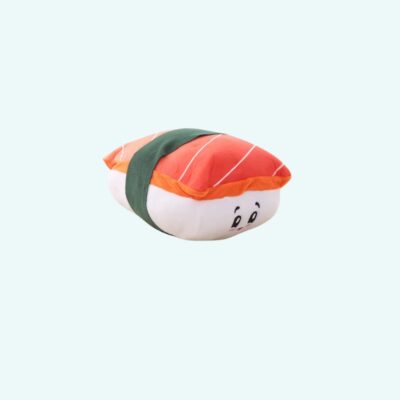 Plush toy shaped like a salmon sushi, soft and fluffy, with an orange striped slice of salmon on top of white rice. A green fabric band represents the seaweed. The sushi has a smiling face for a playful and adorable design.