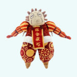 An Esquie plush in red and gold Clair Obscur: Expedition 33 on a solid light blue background