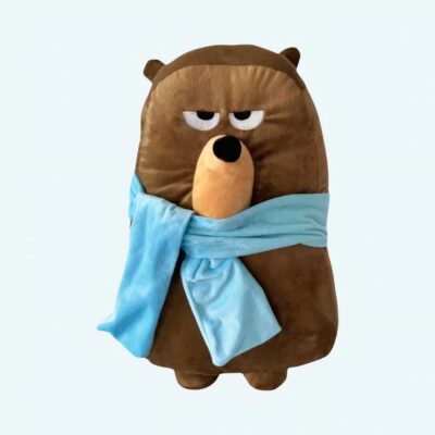 Duolingo plush Falstaff with a grumpy face and light blue scarf, designed like a brown bear with a unique look and endearing expression. The perfect companion for kids and parents alike.