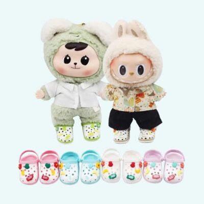 Crocs-style clogs for Labubu plush toy placed beneath two small plushies wearing them, on a very light blue background.