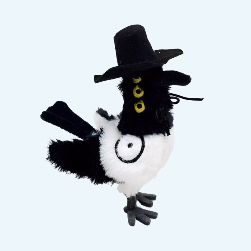 K-pop Demon Hunters plush Sussie the magpie wearing a black hat and three yellow eyes on a sky blue background.