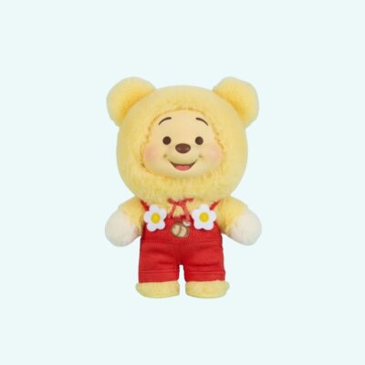 Winnie the Pooh plush toy in Labubu style, yellow with red floral dungarees, on a sky blue background